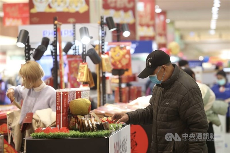 前副總統、中研院院士陳建仁21日說,追求零確診已不切實際,應要有「與病毒共存」心理準備。圖為民眾19日戴口罩採買春節應景商品。(中央社檔案照片)
