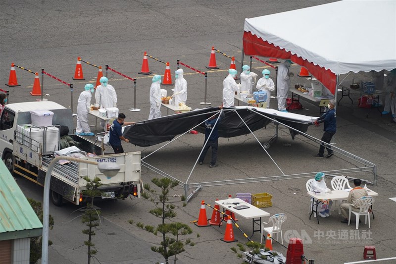 高雄市21日再新增10人確診染疫,其中包含與高雄港新光輪相關者7例,高雄港34號碼頭已開設快篩站,工作人員搭起棚架,助擴大篩檢作業順利進行。中央社記者董俊志攝 111年1月21日