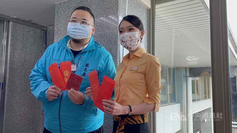 為迎接搭乘「虎虎生風」彩繪機首航抵金門,金門縣政府21日大陣仗迎賓,觀光處長丁健剛(左)親自到場致贈機上乘客好禮,祝福新年如虎添翼、虎虎生風。中央社記者黃慧敏攝 111年1月21日