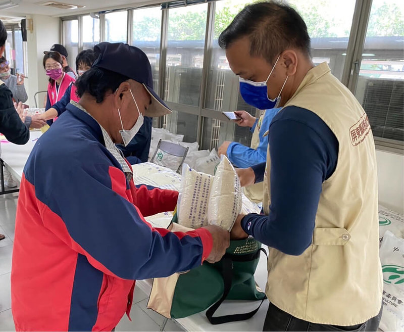 屏東車城福安宮響應縣府歲末關懷活動,由於COVID-19本土疫情當前,為讓弱勢家庭能在年節過好年並兼顧防疫,縣府做好人流安排,讓民眾能夠安心領取福安宮提供的新台幣1000元紅包及10公斤白米。(屏東縣政府提供)中央社記者李卉婷傳真 111年1月21日