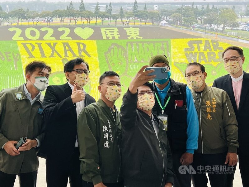屏東熱帶農業博覽會22日開幕,縣長潘孟安(前中)與政府機關人員在彩繪稻田前自拍留念。中央社記者李卉婷攝 111年1月22日