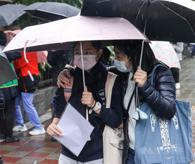 111學年度學科能力測驗22日進入第2天考試。圖為家長撐著傘陪考生前往考場應試。中央社記者鄭清元攝 111年1月22日