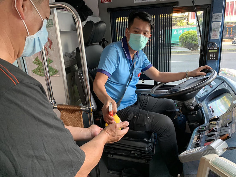 因應疫情,高雄市政府24日宣布,要求公共運輸業者比照3級警戒加強防疫,包含增加清消頻率等;行經指定隔離醫院或疫情嚴重區域的公車路線,駕駛也會為乘客噴灑酒精消毒手部。(高雄市政府提供)中央社記者曾以寧傳真 111年1月24日