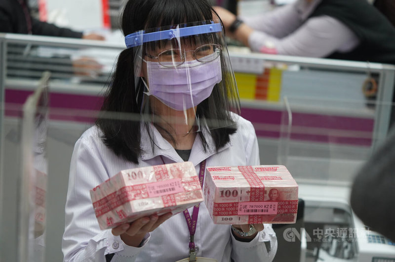 農曆新年即將到來,台灣銀行24日起開放民眾臨櫃換新鈔;行員戴上面罩,加強防疫。中央社記者徐肇昌攝 111年1月24日