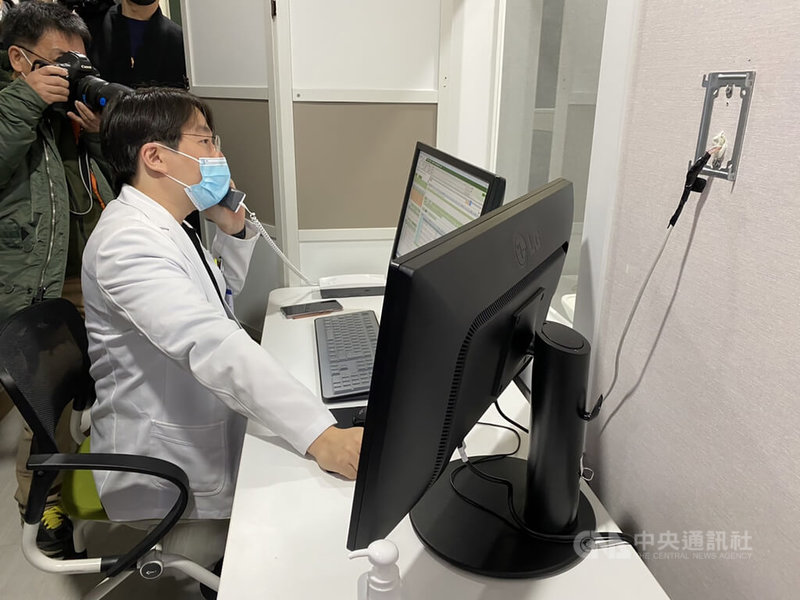 京畿道安城市的安城醫院設立專供居家治療者現場問診中心,醫生與患者在玻璃兩側透過電話溝通問診。中央社記者廖禹揚京畿道安城市攝 111年1月25日