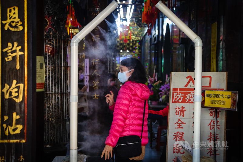 中央流行疫情指揮中心25日公布,國內新增38例COVID-19確診病例,其中13例為本土個案。國內疫情延燒,新北市一處宮廟在入口處設置消毒水噴灑裝置加強防疫。中央社記者王騰毅攝 111年1月25日