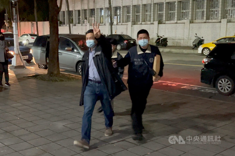 菱光科技董事長黃育仁(左)被控在擔任聯昌公司董事長任內,涉嫌不實交易導致公司損害。台北地檢署25日約談黃育仁到案說明。面對媒體,黃育仁數度比出3的手勢。中央社記者蕭博文攝 111年1月25日