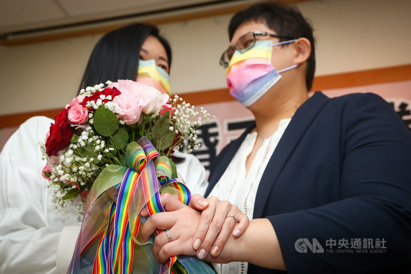 台灣、新加坡跨國同性伴侶小C(左)與美蘋(右)26日到台北松山戶政事務所辦理結婚登記,兩人開心秀出手上婚戒,互許終身。中央社記者王騰毅攝 111年1月26日