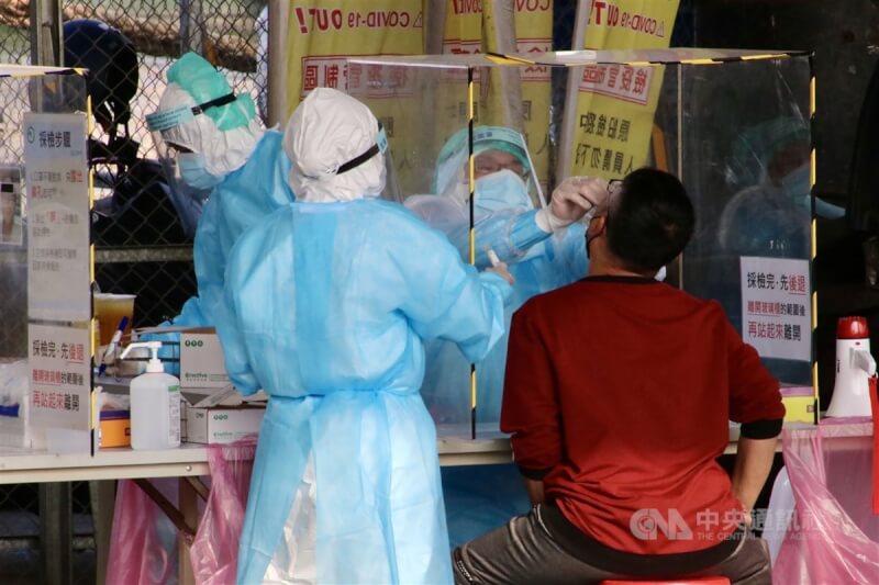 高雄市仁武區某國中學生26日確診。圖為醫護人員為民眾採檢。(中央社檔案照片)