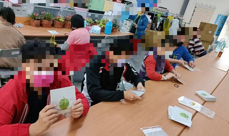 屏東棗農潘志民委由社福單位身心障礙者將蜜棗禮盒的英日文說明書裝袋;他表示,農業行銷需要人手、社福單位需要工作、企業需要盡社會責任,這種3贏模式,歡迎大家多多模仿複製。(潘志民提供) 中央社記者郭芷瑄傳真 111年1月26日