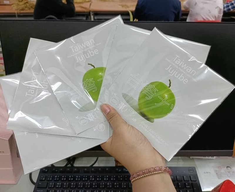 屏東棗農潘志民外銷蜜棗,委由社福單位身心障礙者將英日文說明書裝袋,他說,把給廠商賺的留給社福單位是3贏策略。(潘志民提供) 中央社記者郭芷瑄傳真 111年1月26日