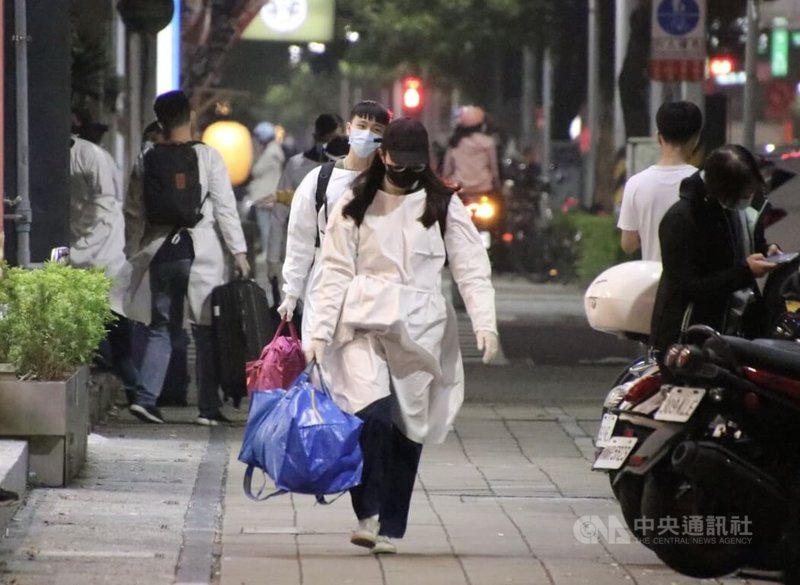 高雄左營區連鎖牛排館員工26日晚間接獲通知,帶著行李到店家集合,隨後穿上隔離衣。中央社記者董俊志攝 111年1月27日