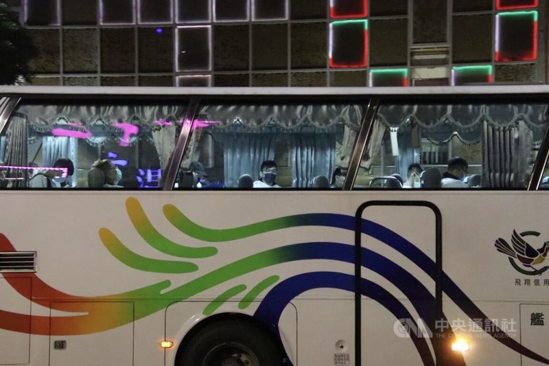 高雄左營區連鎖牛排館員工26日晚間接獲通知到店家集合,隨後穿上隔離衣、搭乘遊覽車離去。中央社記者董俊志攝 111年1月27日