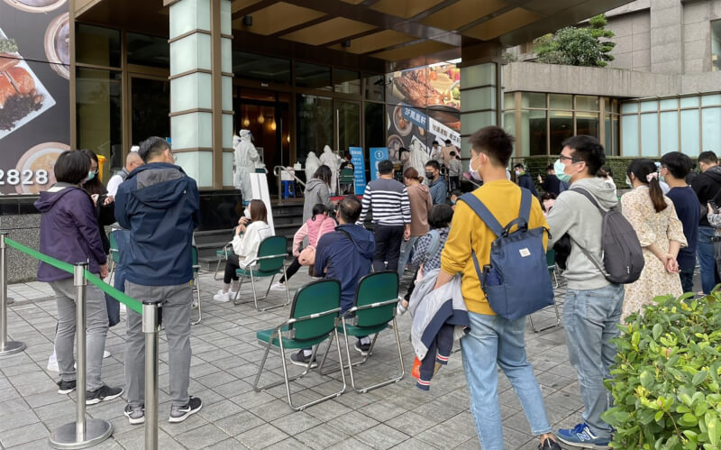 指揮中心28日公布,新增4例與宜蘭礁溪長榮鳳凰酒店群聚相關個案,將回溯採檢飯店住客至1月14日。圖為民眾在酒店外等候採檢。(宜蘭縣政府提供)