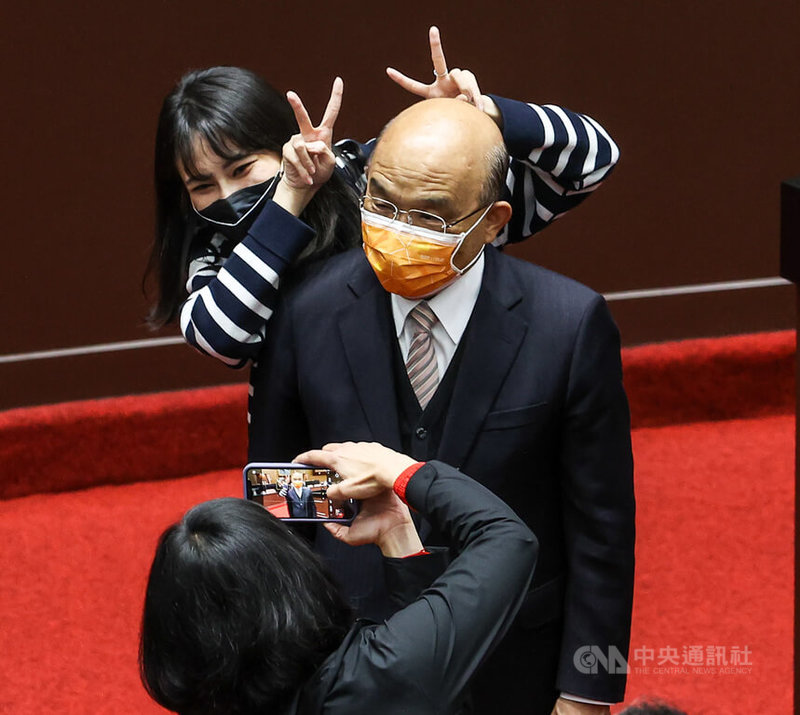 立法院臨時會院會28日三讀通過中華民國111年度中央政府總預算,行政院長蘇貞昌(橘色口罩者)晚間到立法院致意,民進黨立委賴品妤(後)上前開心合影。中央社記者鄭清元攝 111年1月28日