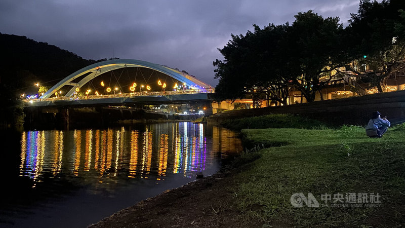 新北市坪林區公所整理北勢溪水岸,以光雕裝扮河濱地景,入夜時藍色坪林拱橋展現與白天不同風貌,呈現寧靜山城另一番美景。中央社記者黃旭昇新北攝 111年1月29日