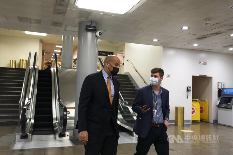一名記者趁民主黨籍參議員布克(左)前往搭乘美國國會地下小火車時進行堵訪。中央社記者徐薇婷華盛頓攝 111年1月30日