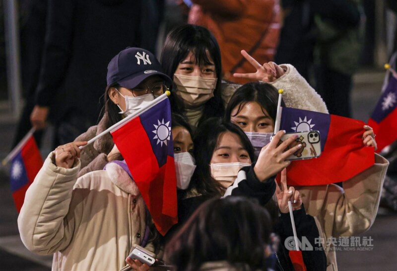 經濟學人資訊社10日公布2021民主指數報告,台灣排名第8。圖為民眾參加總統府元旦升旗典禮開心與國旗自拍。(中央社檔案照片)