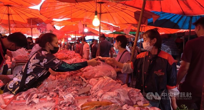 泰國豬肉價格飛漲,民眾攤商都要勒緊褲帶面對這波漲價潮。圖為曼谷孔提市場內民眾向攤商購買豬肉景象。中央社記者呂欣憓曼谷攝 111年2月10日