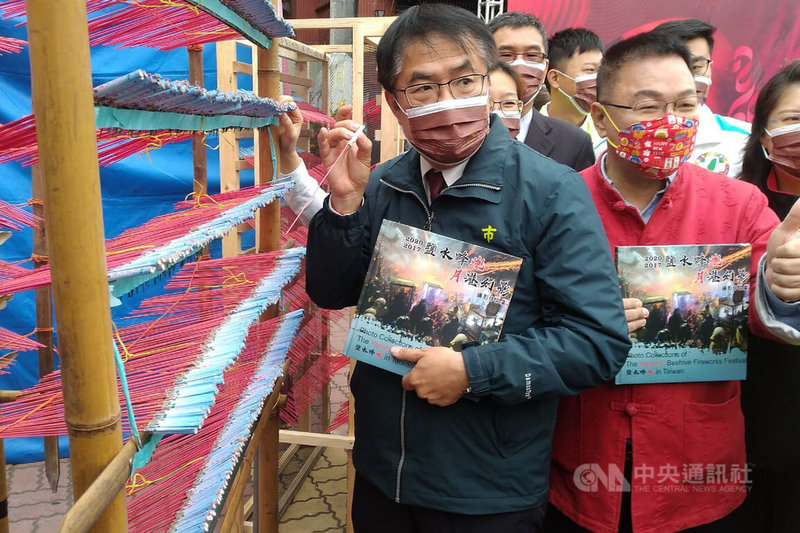 台南市長黃偉哲(前左)11日到鹽水武廟出席蜂炮活動宣傳記者會,並體驗製作蜂炮城。中央社記者楊思瑞攝 111年2月11日