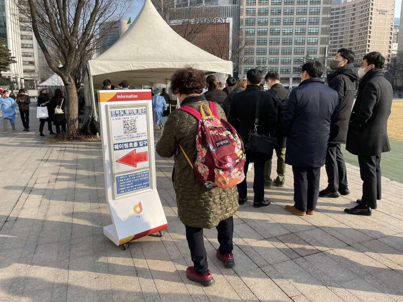 韓國COVID-19單日確診新增5萬4619例,連續5天超過5萬例。圖為韓國首爾市政廳前檢測站。(中新社)