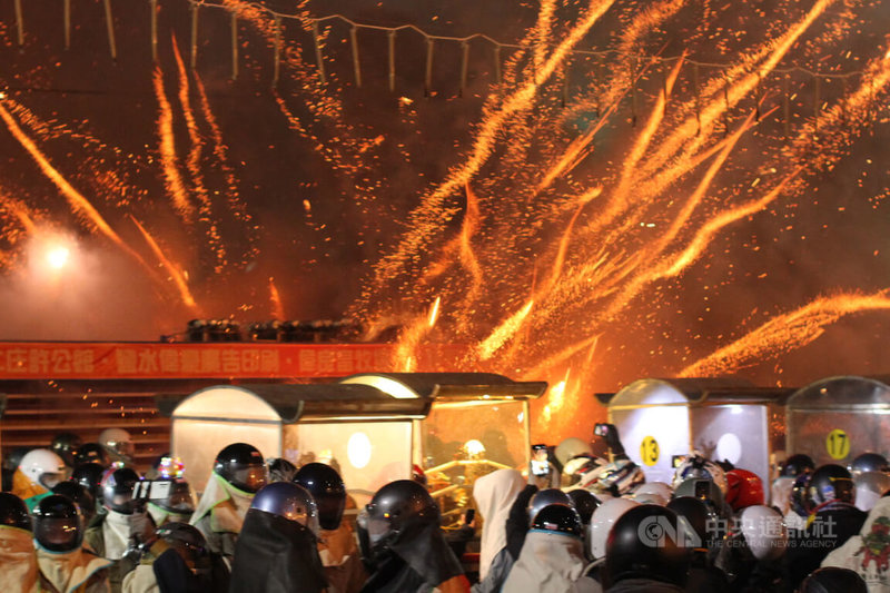 一年一度的台南鹽水蜂炮活動15日元宵節晚間熱鬧登場，儘管今年因應疫情縮小規模舉辦，當第一座炮城在武廟前施放時，仍吸引許多民眾圍觀。中央社記者楊思瑞攝  111年2月15日