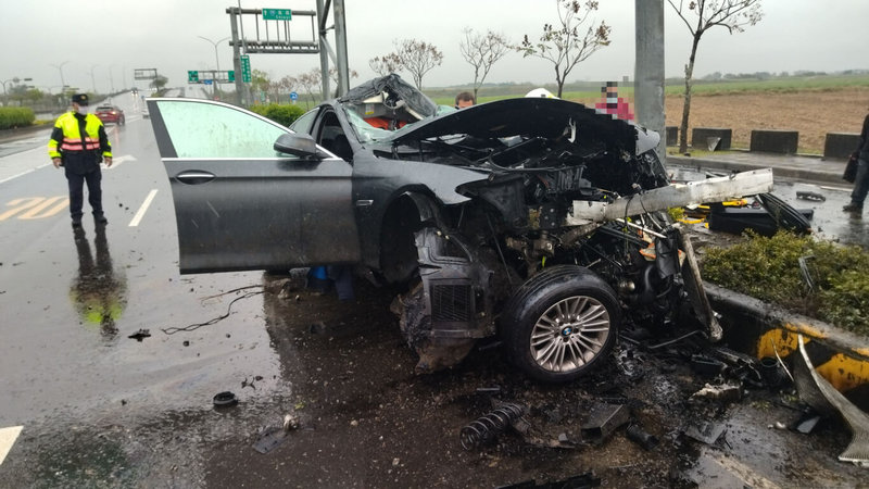 嘉義縣高鐵大道太保段23日下午發生車禍事故,一輛黑色轎車疑因雨天打滑,撞上分隔島導致車頭全毀,男駕駛一度受困車內,經消防局搶救後脫困,送醫救治。(嘉義縣消防局提供)中央社記者蔡智明傳真 111年2月23日