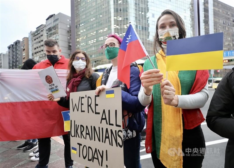俄羅斯對烏克蘭發動軍事行動,多名在台烏克蘭人與外籍人士25日集結在莫北協駐台代表處外,舉出標語聲援烏克蘭。中央社記者張皓安攝 111年2月25日