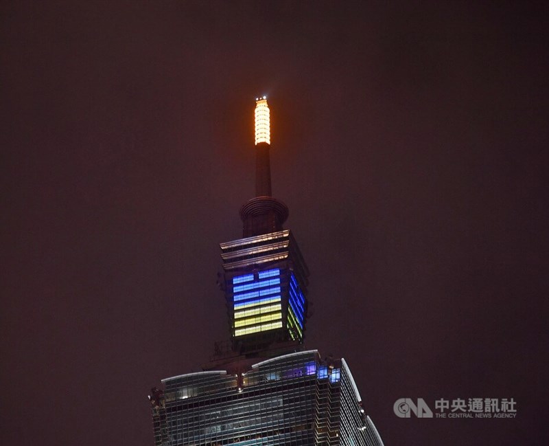 台北101大樓26日晚間在頂冠燈處以藍黃燈光點亮烏克蘭國旗圖樣,為烏克蘭安全、和平祈願,也盼望世界和平穩定。中央社記者王飛華攝 111年2月26日