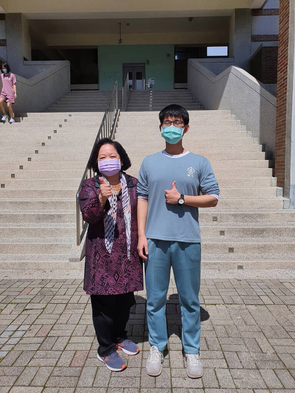 苗栗縣國立竹南高中鍾坤達(右)幼年喪父,依靠越南來台的母親獨自扶養長大,他感念母親辛勞,學測拚出51級分,他希望將來能就讀為民喉舌的科系。左為竹南高中校長呂淑美。(竹南高中提供)中央社記者管瑞平傳真 111年3月1日