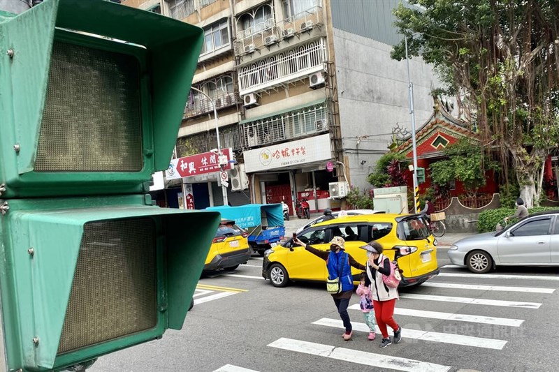 全台3日上午9時左右無預警傳出停電消息,各地都有民眾回報停電災情,台電正查明原因。圖為台北市木柵一處路口號誌燈異常,行人舉手過馬路。中央社 111年3月3日
