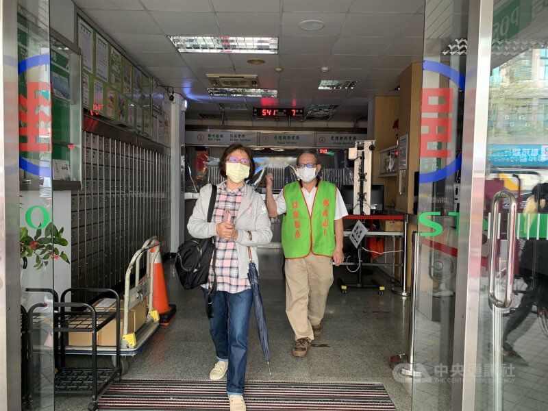 郵局停電,志工(綠背心者)說明無法營業。(中央社)