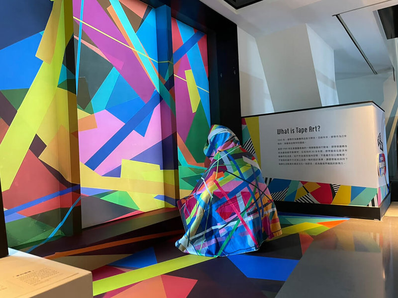 「聚膠行動#TapeArt 2.0 @KAOHSIUNG」特展現於高雄駁二特區展出,主辦單位並在高雄洲際酒店另外舉行微型展外展,近20名心路青年及志工4日參訪,有人開心體驗將展品穿上身。(瘋設計提供)中央社記者王寶兒傳真 111年3月4日