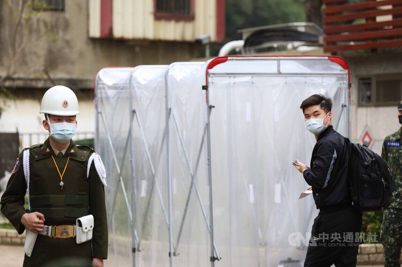 首梯接受新制14天教育召集的民眾,5日於桃園山腳國小報到,量測體溫後穿越消毒走廊。中央社記者游凱翔攝 111年3月5日