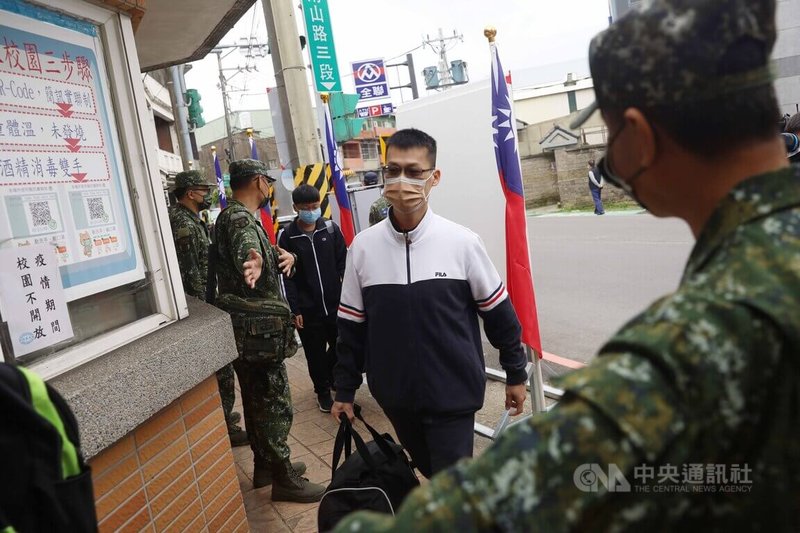 首梯接受新制14天教育召集的民眾,5日於桃園山腳國小報到,軍方人員在門口引導召員入營。中央社記者游凱翔攝 111年3月5日