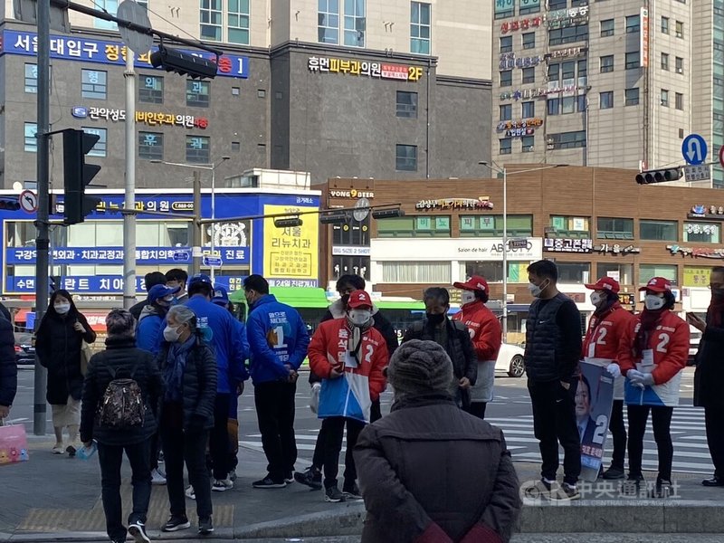 執政黨共同民主黨便面臨變天危機,共同民主黨李在明與最大在野黨國民力量尹錫悅民調支持度至最後一刻都維持在誤差範圍內的極小差距,專家都認為選舉結果難以預測。圖為兩黨同時在首爾鬧區路口拉票。中央社記者廖禹揚首爾攝 111年3月8日