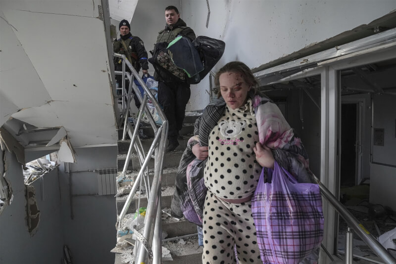 去年3月9日，俄羅斯轟炸烏克蘭東南部城市馬立波一間兒童醫院，一名受傷孕婦走下階梯。（美聯社）