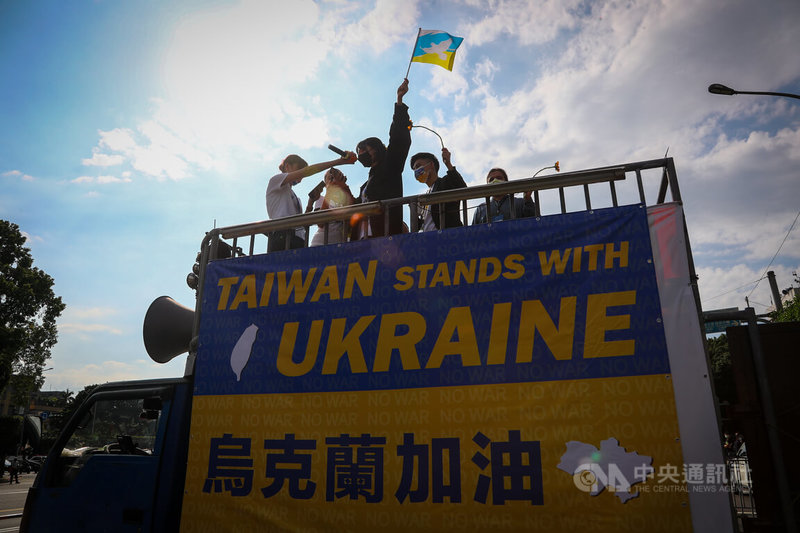 俄烏戰事持續，在台烏克蘭人等各國人士13日下午在台北舉行「台灣聲援烏克蘭和平大遊行」，參與者在前導車上率領眾人高歌，表達反戰訴求。中央社記者王騰毅攝 111年3月13日
