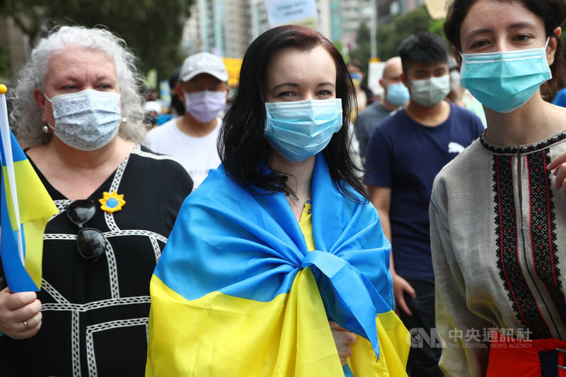 民間團體13日在台北發起「台灣聲援烏克蘭和平大遊行」，不少在台外籍人士參與，有人身披大型烏克蘭國旗熱情響應。中央社記者王騰毅攝　111年3月13日