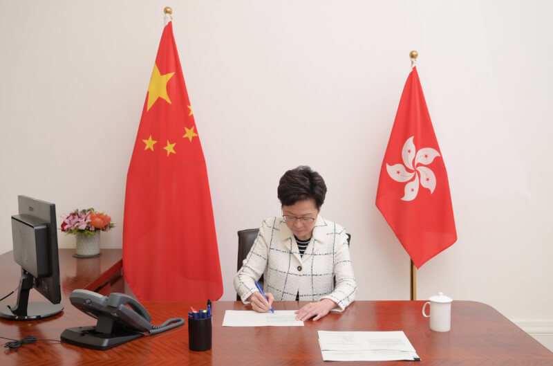 BBC報導,港府使用越來越多北京官腔官調,凸顯香港自治權被剝奪。圖為香港行政長官林鄭月娥2020年簽署生效「港區國安法」。(中通社)