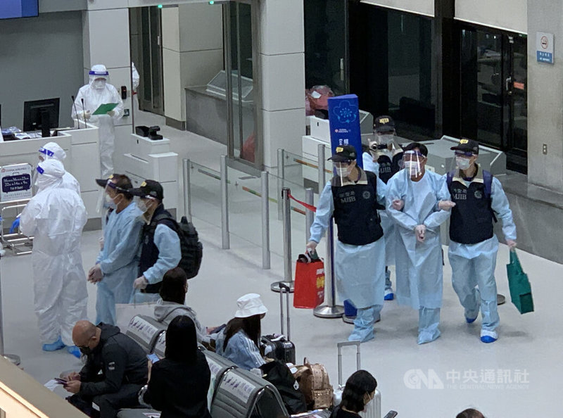 台灣籍蕭姓及陳姓男子在史瓦帝尼走私犀牛角,各遭判刑11年並於當地服刑近5年,2人請求返台服刑獲准,法務部調查局派員將2人押解返台。圖為蕭男與陳男17日晚間在調查局人員戒護下入境。中央社記者葉臻攝 111年3月17日