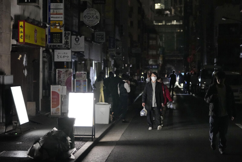 日本福島縣外海16日深夜發生強震，連遠在關東地方的9都縣也受影響，一度多達約210萬家戶短暫停電。圖為民眾走在停電的東京新橋街頭。（共同社）