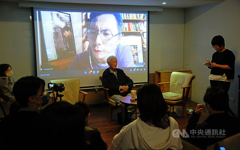 春山出版社18日晚間在左轉有書書店舉辦了紀錄片「時代革命」座談會，邀請周冠威（投影者）透過視訊和片中受訪的資深香港時評家李怡（中），以及媒體人張潔平（右立者）對談。中央社記者沈朋達攝 111年3月19日