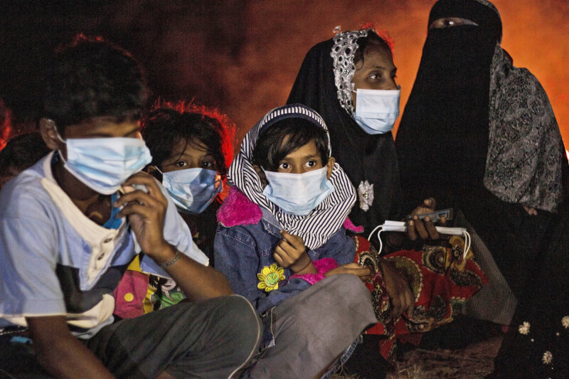 圖為去年6月洛興雅人從孟加拉難民營搭船抵達印尼外海島嶼，婦女與孩童坐在火堆旁。（美聯社）