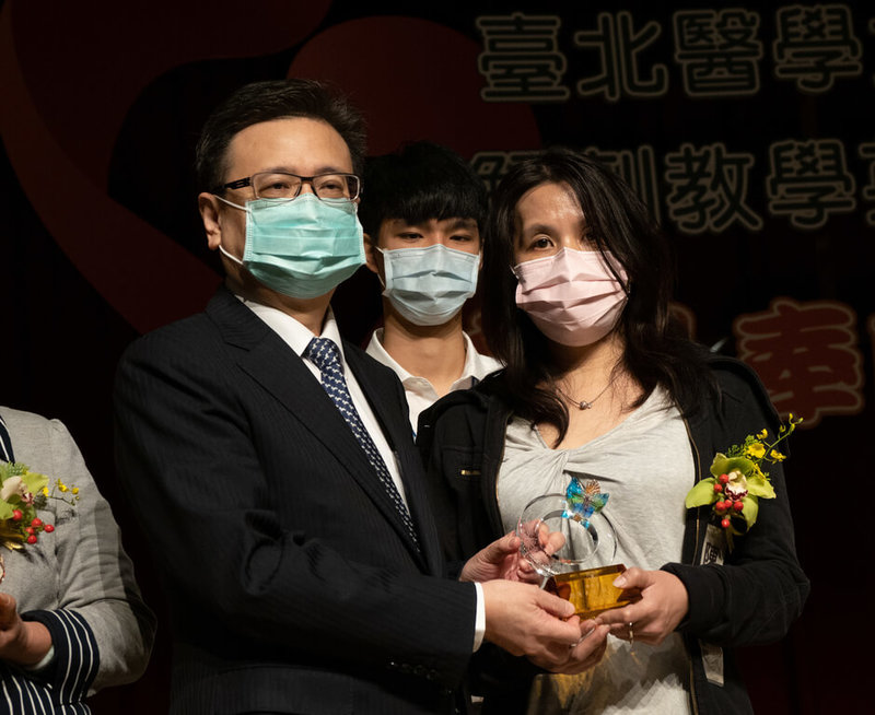 台北醫學大學22日舉行解剖教學英靈追思紀念會,今年共有9位大體老師無私奉獻自己的軀體,作為醫學教學之用。校長林建煌(左)向大體老師梁奶奶的女兒梁馨心(右)表達感謝。(台北醫學大學提供)中央社記者江慧珺傳真 111年3月22日