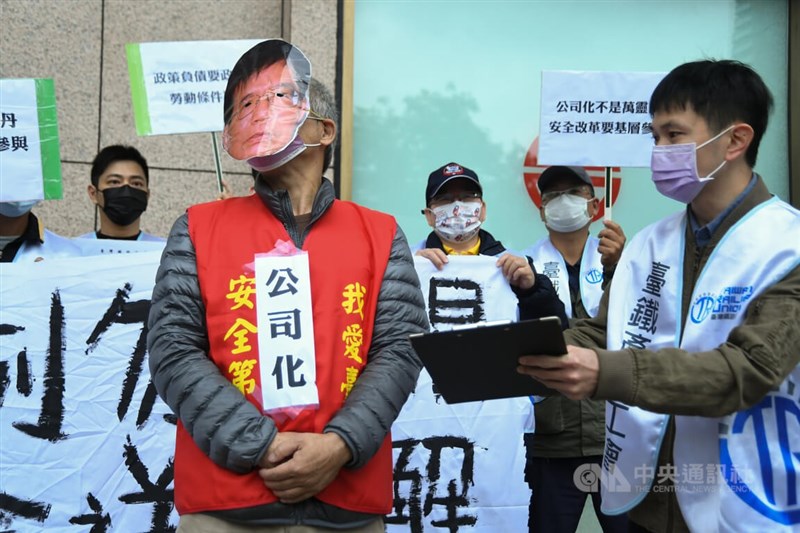 行政院版「國營台鐵公司化條例草案」已送到立法院,台灣鐵路產業工會23日上午在台北車站舉行「條例勿闖關,工會送調解」記者會,工會成員戴上交通部長王國材面具上演行動劇。中央社記者趙世勳攝 111年3月23日