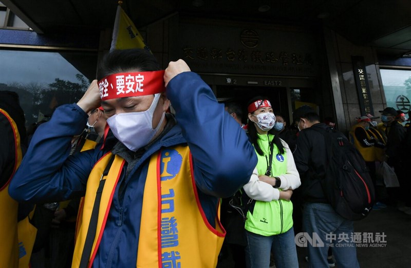台鐵企業工會認為,公司法草案未與工會溝通,政府推動台鐵公司化的做法是假改革,23日號召千名員工在台北車站東門外廣場集結。圖為台鐵員工綁上紅布條準備上街抗議。中央社記者趙世勳攝 111年3月23日