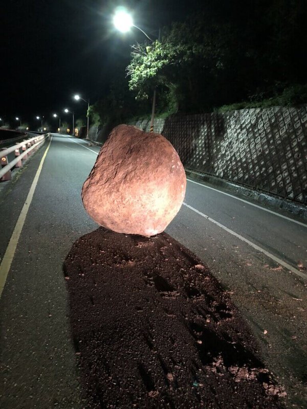花蓮近海23日凌晨發生規模6.6地震,台東震度6弱,長濱永福路段有一塊約1.8公尺高、10噸重的巨石掉落路面。(劉世鴻提供)中央社記者盧太城台東傳真 111年3月23日