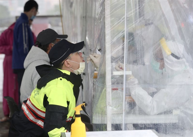 國內28日新增34例本土，基隆小吃店衍生警察群聚占12人。圖為基隆員警27日接受採檢。（中央社檔案照片）