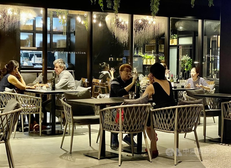 新加坡29日起擴大鬆綁社交防疫措施，圖為當晚市區一家餐廳飲酒的民眾。中央社記者侯姿瑩新加坡攝 111年3月29日